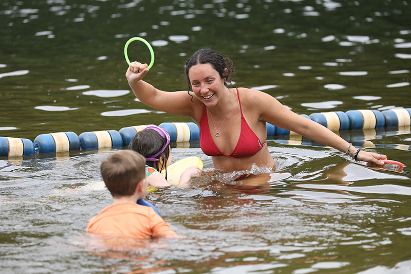 Analucia Lora engages young swimmers in a ring toss game.